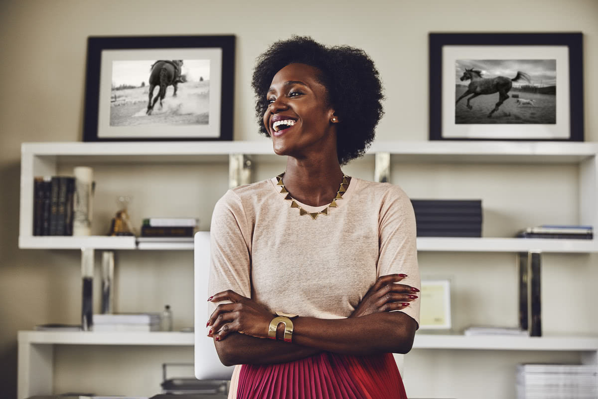 A smiling woman with crossed arms in her office